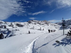 Výstup skupiny lavinového kurzu v zasněžených Alpách.